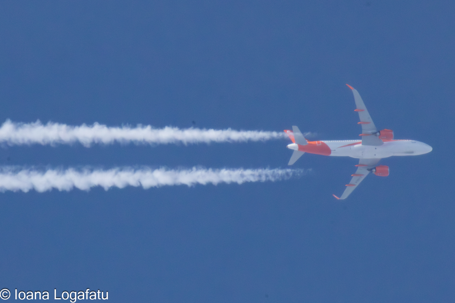 Airplane soaring through a clear blue sky
